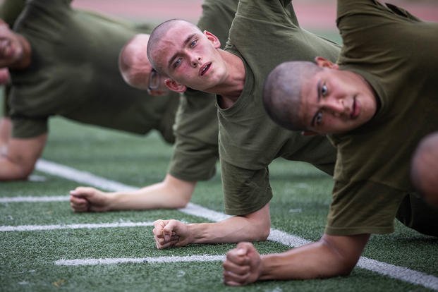 Marine recruits execute a side plank.