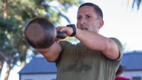 A Marine does a kettlebell swing as part of HITT training.